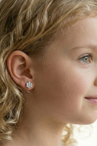 Close-up of a young girl wearing a diamond earring with a soft background